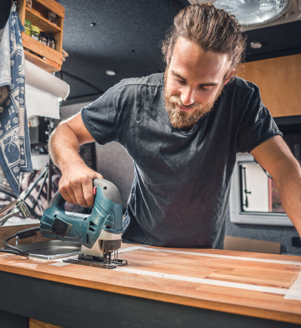 Man working on his camper van conversion Man working on his camper van conversion